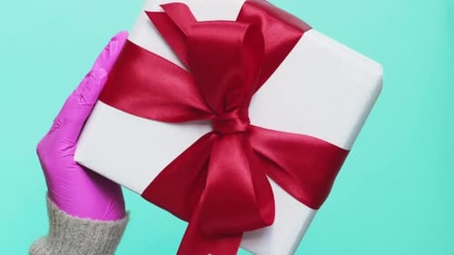 Present Held By Pink-Gloved Hands
