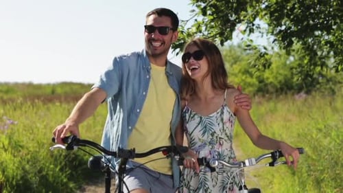 Happy Couple Walking with Bicycles in Countryside