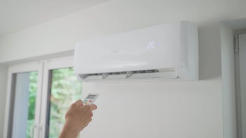 Adjusting Air Conditioner with Remote Control Indoors