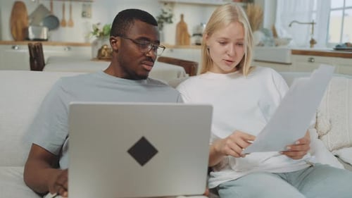 Couple Reviews Documents and Uses Laptop at Home