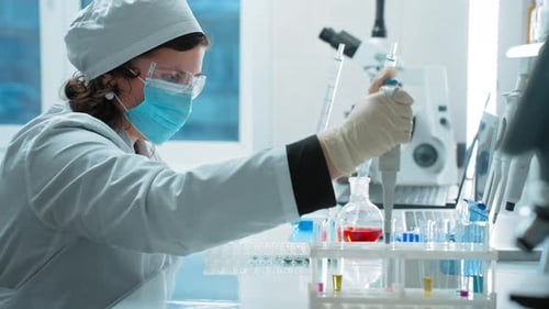 Female Scientist Working with Micropipette in Laboratory