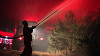 Firefighter Battles Blaze at Night with Water Hose