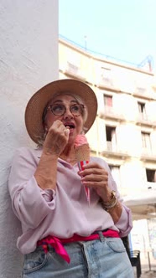 Stylish Senior Woman Eating Ice Cream on a City Street