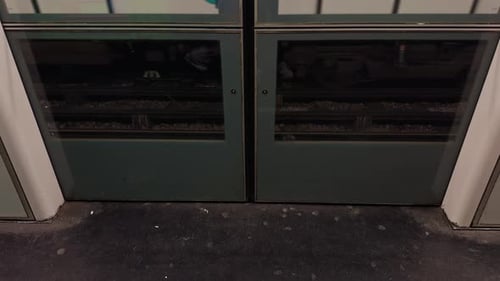A Close Up View of Train Doors with the Tracks Clearly Visible Below the Doors for Commuters and