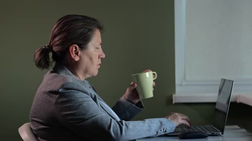 Mulher madura trabalha até tarde no Escritório Corporativo da Empresa