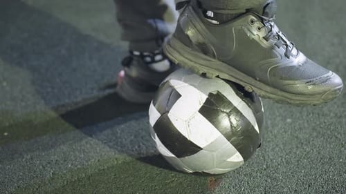 CloseUp of Soccer Player Rolling Ball on Turf at Night