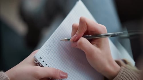 CloseUp Hand View of Lady Writing in Notebook with Pen