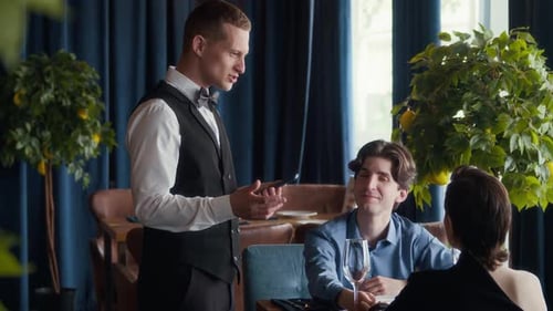 Waiter Listening to Couple Making Order in Restaurant