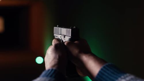 Shooting Gallery-Client benutzt Handfeuerwaffe, um Papierziele mit Munition aus nächster Nähe zu treffen