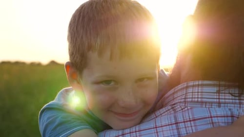 Happy Child Hugging Adult in Sunny Field