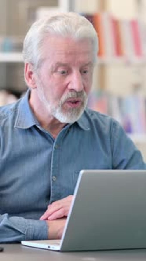 Senior Man Video Calling on Laptop at Desk