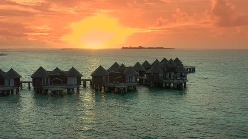 Overwater Villas at the Time Amazing Sunset in Tropical Sea with Coral Reef