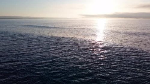 Black Sea with Cool Water Extends Beyond the Horizon Under a Sky with Clouds and a Dawn Sun