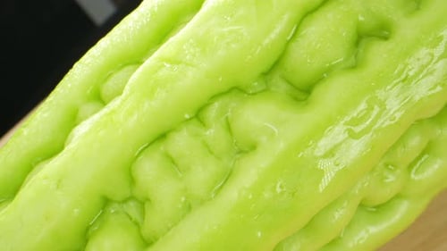 Dans une vidéo macro, une courge amère chinoise scintille sous l'effet de gouttelettes d'eau