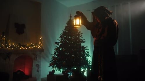Un misterioso hombre encapuchado cree en la Navidad en su cuarto oscuro por la noche