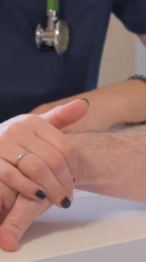 A Family Doctor Talks to a Sick Patient and Comforts Him By Holding His Hand Vertical Video
