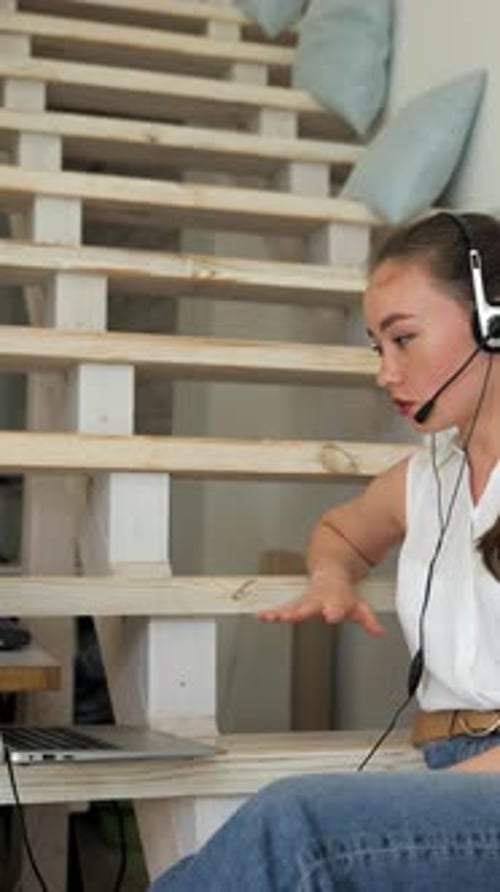 Woman with Headset Using Laptop on Stairs