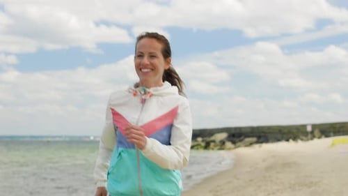 Fitness, Sport And Healthy Lifestyle Concept - Smiling Woman Running Along Beach