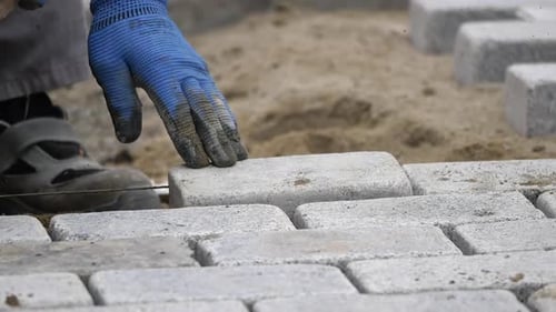 Worker Laying Gray Bricks for Urban Construction