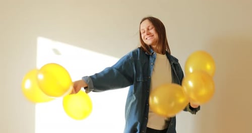 Happy Woman Dances with Yellow Balloons