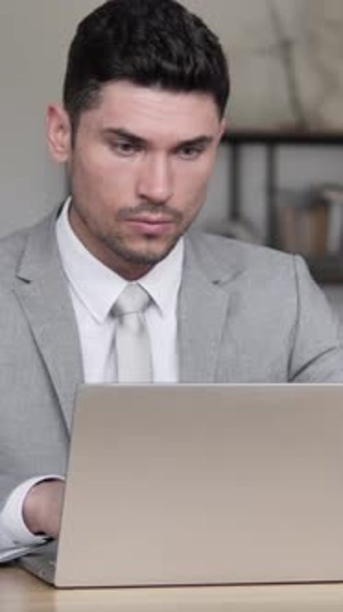 Excited Man in Suit Celebrates Success at Computer