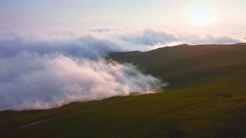 Clouds And Fog Creeping Over Mountain Valley At Sunset, Aerial View From Drone