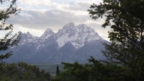 Wyoming teton mountains snowcapped peaks glow with sunset light by drone
