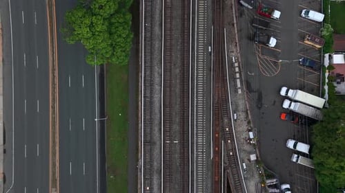 A top down, aerial view of a Long Island Railroad train tracks running through an industrial area.