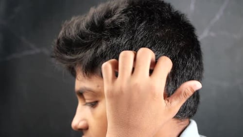 Young Adult Itching Head in Close Up Shot
