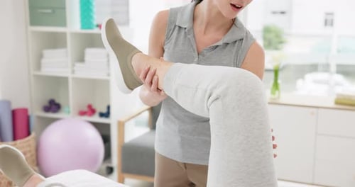 Physical Therapist Assists Patient with Leg Exercise