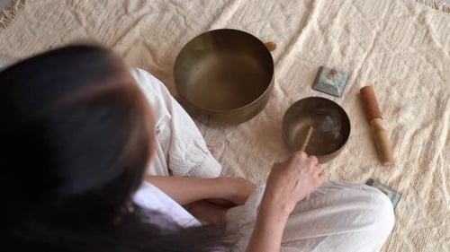 Woman Practices Meditation with Singing Bowls at Home