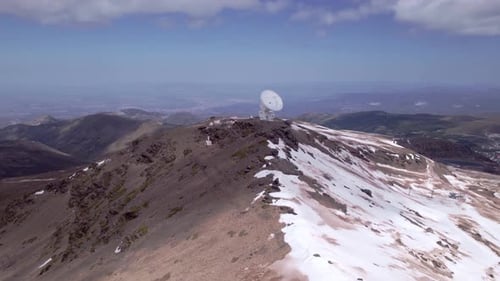 Space research radio telescope. Aerial orbit shot in high snowy peaks. Sierra Nevada. Spain.