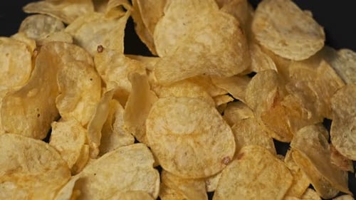Close-up of Tasty Potato Chips on Black Background