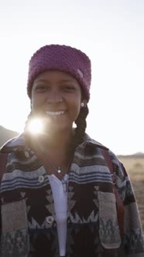 Portrait d'une jeune routarde souriante aux tresses profitant d'une journée ensoleillée dans le désert, belle femme africaine