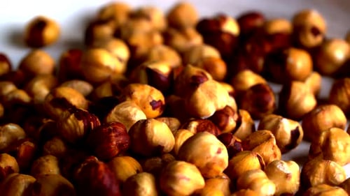 A rotating view of golden roasted hazelnuts with rich brown tones and natural textures. Perfect for