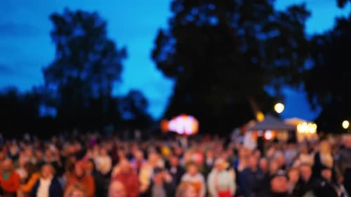 Une foule diversifiée s'est rassemblée sous le ciel qui s'assombrit lors d'un événement extérieur animé rempli de