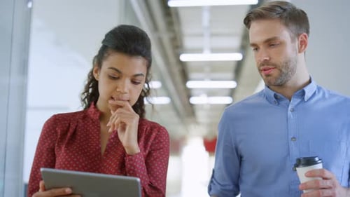 Closeup Multiethnic Colleagues Talking While Walking with Tablet Computer on Modern Office