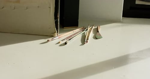 Daylight streaming through window is casting shadows, highlighting brushes to reveal changing light