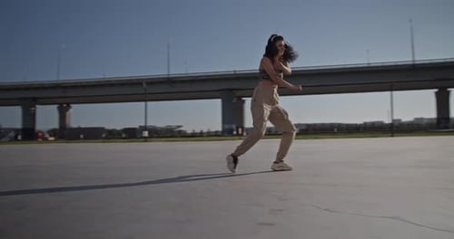 Stylish Young Woman Dances in an Urban Setting