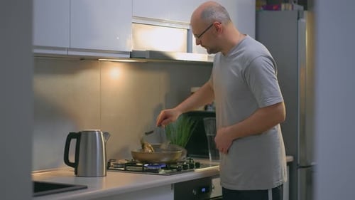 Man Cooking Food in Modern Kitchen at Home
