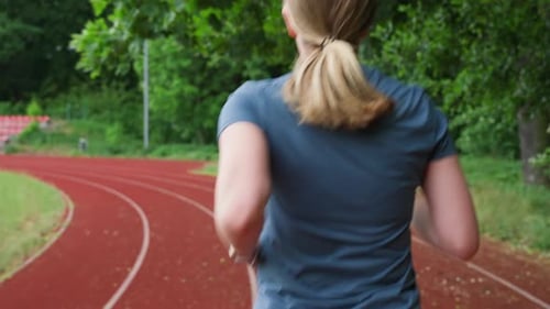 Woman Jogging on Running Track at Sport Stadium