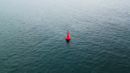 Closeup Aerial View of a Red Navigation Buoy Floating in the Calm Waters of the Sea The Buoy Ensures
