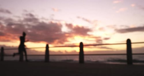 Silhouette Jogging on Beach at Sunset