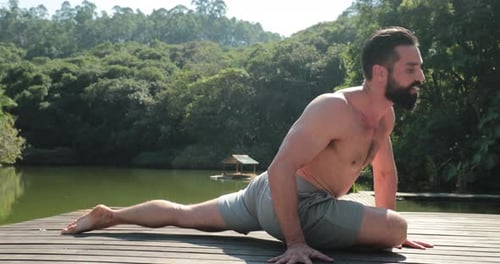 Fit man training Yoga outdoors
