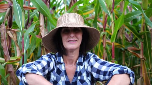 Happy Smiling Female Farmer Looks Into Camera Sitting Near Corn Field Portrait of Adult Tired