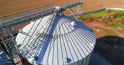 Aerial view. Metal grain elevator in agricultural zone. Grain warehouse