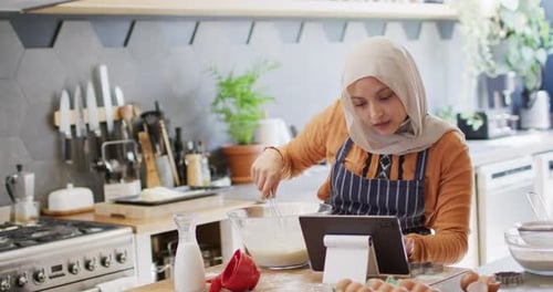 Young Woman Baking at Home with Tablet Recipe