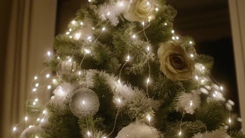 Beautiful Christmas tree with white garland and decoration, close up parallax in slow motion