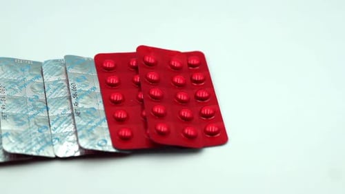 Blister Packs of Red Pills on White Surface