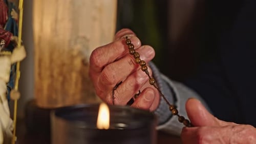 Hands Of Lady Praying Rosary And Statues Of Jesus Mary And Angel